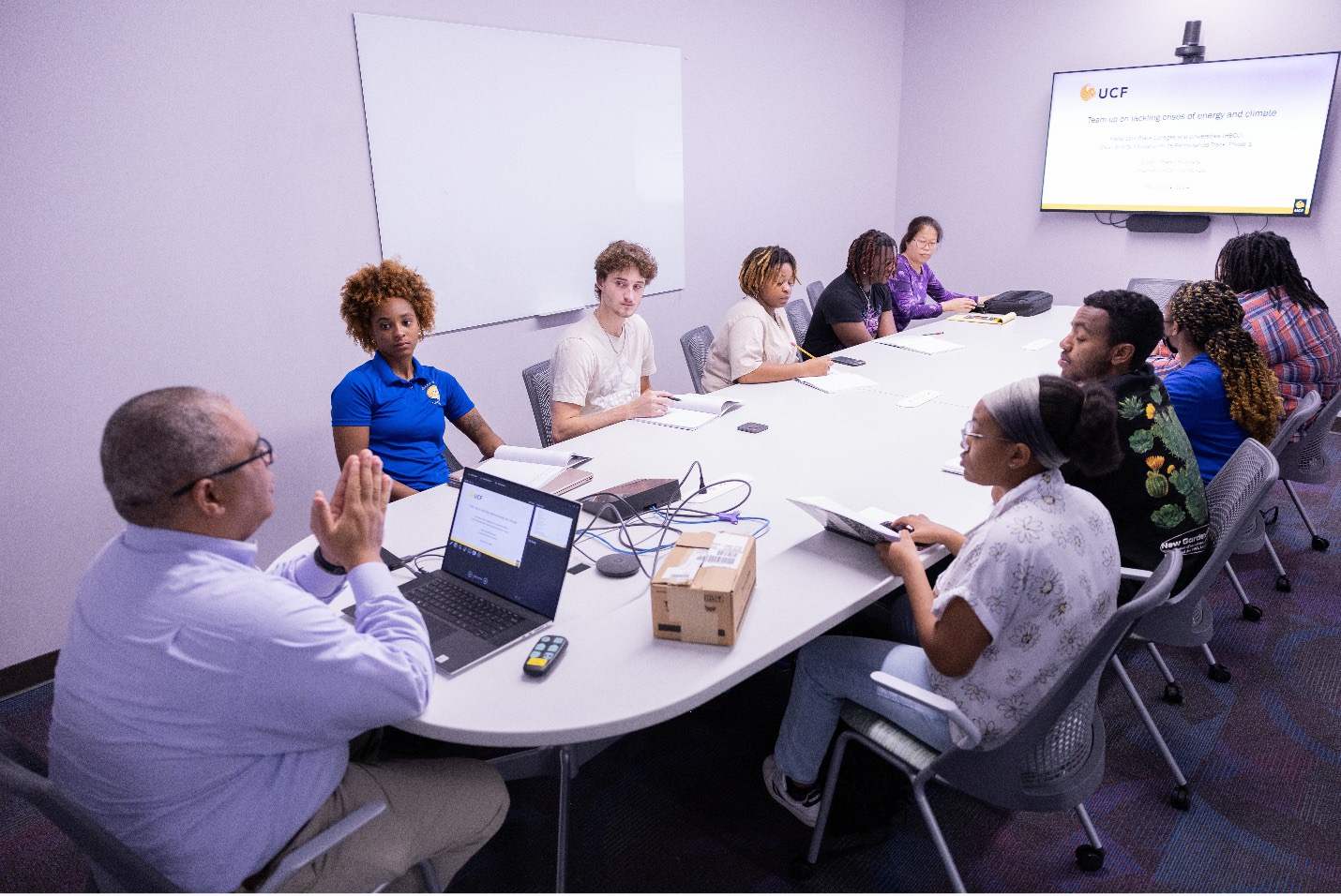 Students and instructor discussing at a conference table